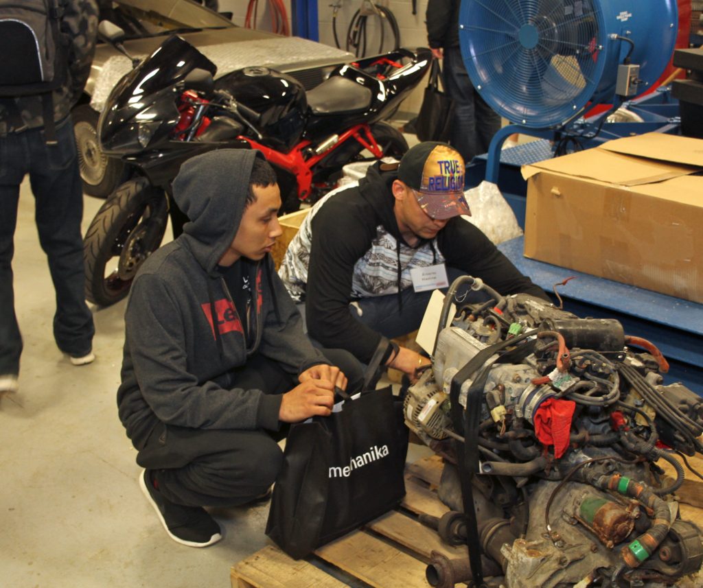 Attendees examine as engine during the Automechanika event at WCC. (Photo by Lynn Monson)