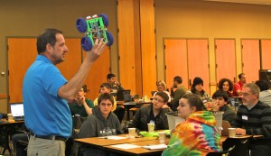 Bob Jones, an instructor with Square One Education Network, holds the starting platform of an autonomous vehicle model as he talks with area high school teachers and students during a workshop at Washtenaw Community College. Photo by Lynn Monson