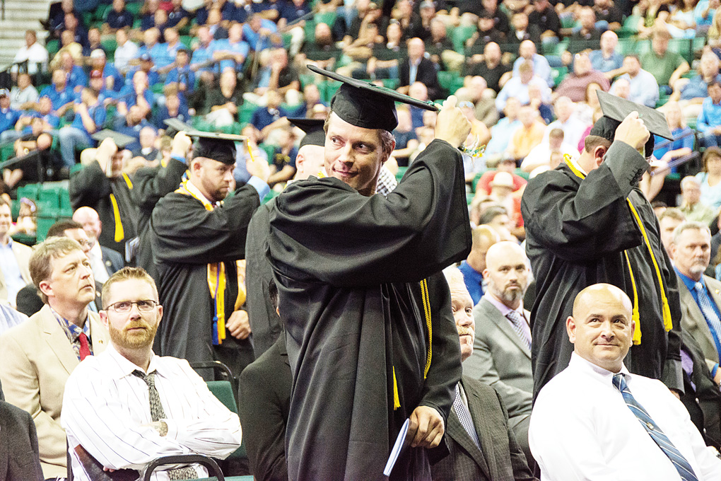 UA graduates move the tassels on their caps at the Aug. 18 completion ceremony. (Photo by CJ South)