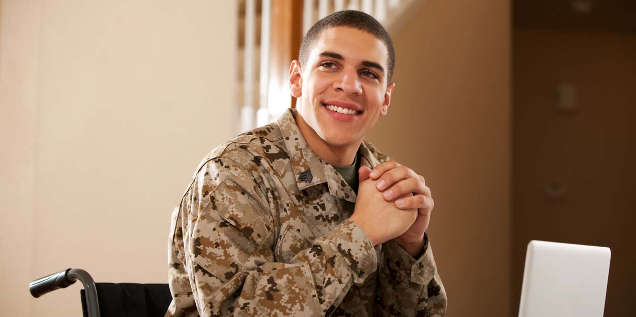 vet in wheelchair smiling at computer